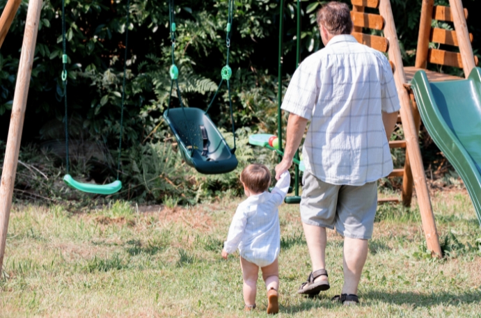 Parent jouant avec un enfant sur un portique en bois